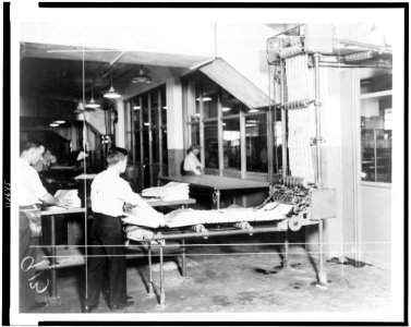 Interior view of newspaper delivery room showing man taking stack of newspapers from machine) - World-Telegram photo LCCN95506971