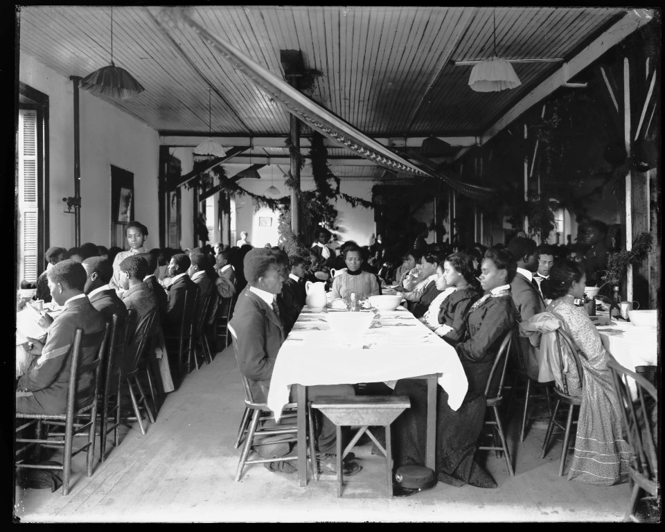 Interior view of dining hall, decorated for the holidays, with students sitting at tables at the Tuskegee Institute LCCN2009631999