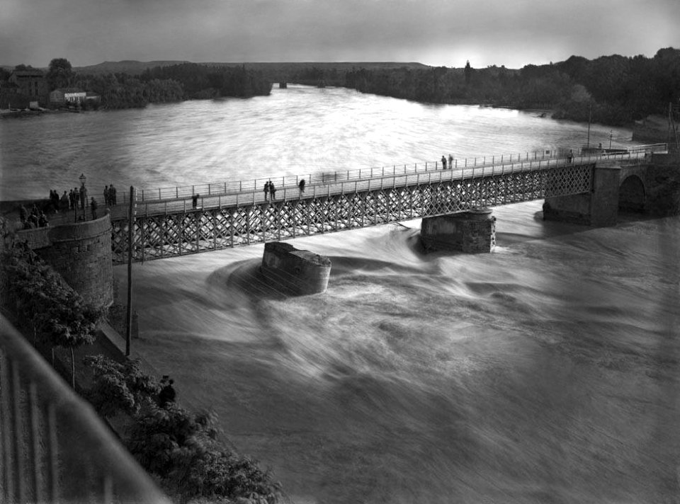 Inundació de Lleida per la crescuda del riu Segre i un pont ple de gent vist des d'un balcó (restored)