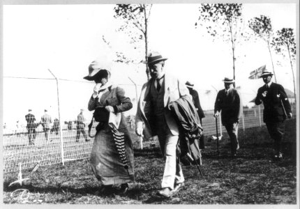 Isaac N. Seligman and wife, Guta Loeb Seligman, full-length, walking alongside fence LCCN96503957