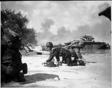 It appears that one Marine is relieving another on the beach at Saipan but they are really crawling under enemy fire... - NARA - 532381
