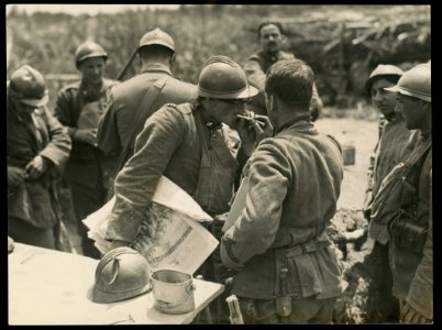 Italian soldier holding illustrated newspaper gets his cigarette lit by another soldier near Piave River, Italy LCCN2016652129