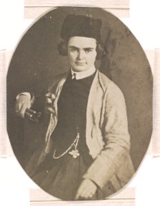 Harriet Hosmer, half-length studio portrait, facing front, seated with right arm resting on the back of a chair, she is holding sculpting tools in her right hand, left hand rests on her lap LCCN2015651564