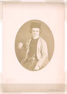 Harriet Hosmer, half-length studio portrait, facing front, seated with right arm resting on the back of a chair, she is holding sculpting tools in her right hand, left hand rests on her lap LCCN2015651563
