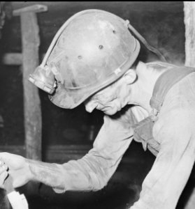 Harry Fain, coal loader, makes stemmings which are used in proper placing of powder charge. Inland Steel Company... - NARA - 541473 (detail of miner's helmet) photo