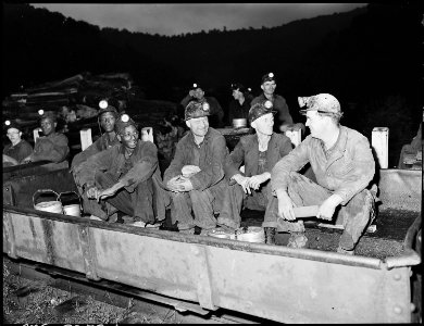 Harry Fain, second from right, seated in shuttle car on mantrip before going underground. Inland Steel Company... - NARA - 541486
