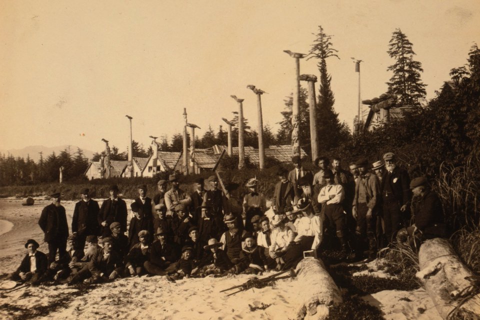 Harriman Alaska Expedition members pose on beach at deserted Cape Fox village, Alaska, 1899