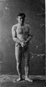 Harry Houdini, full-length portrait, standing, facing front, in chains LCCN96518776 photo