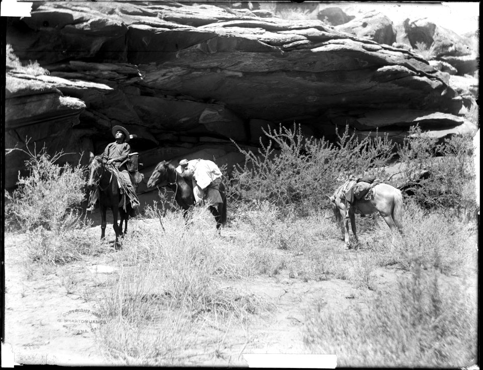 Havasupai Indian man on horseback, with two pack-horses, standing beneath a cliff overhang, ca.1899 (CHS-3784)