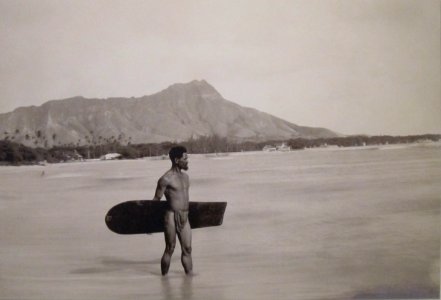 Hawaiian with surfboard and Diamond Head in the background