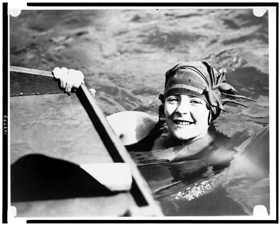 Head-and-shoulders portrait of young woman, wearing fancy bathing cap, in water LCCN94503126