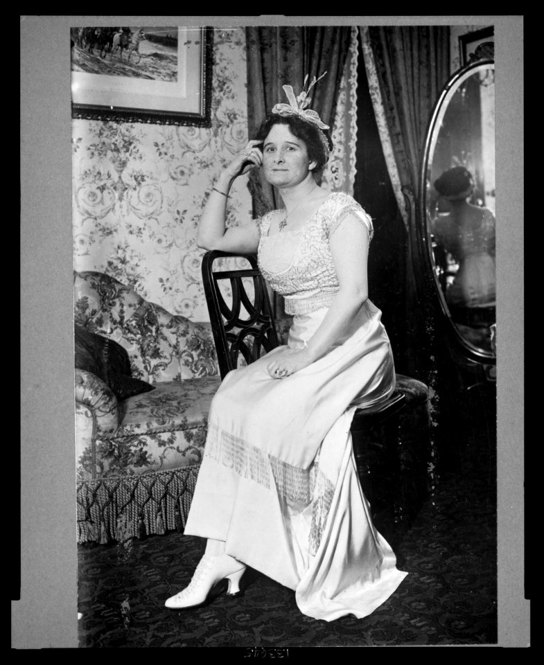 Helen Hathaway Britton, full-length portrait, seated sideways on chair, facing front LCCN2003689092
