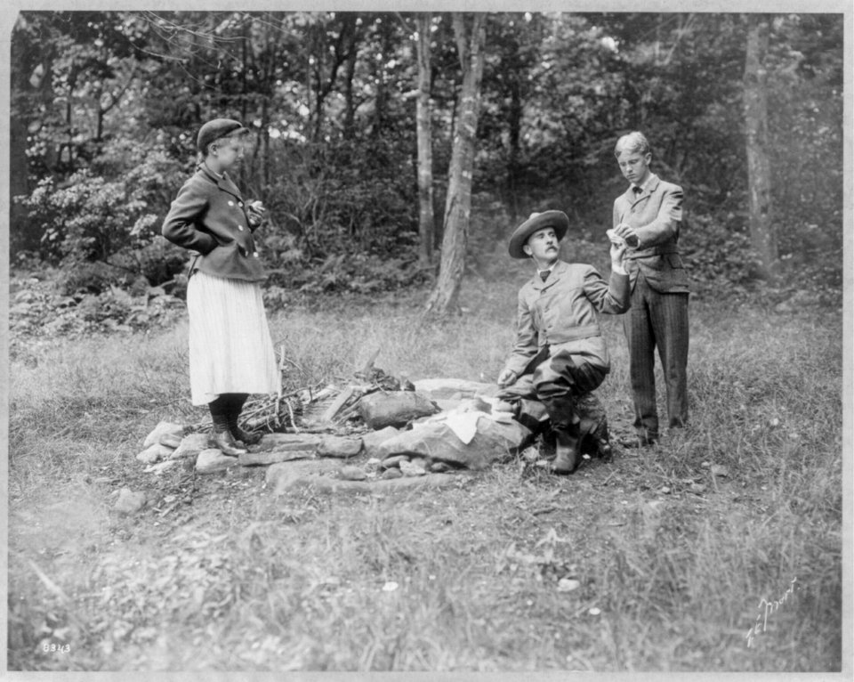Henry Van Dyke and 2 others with sandwiches at campfire LCCN2003653812