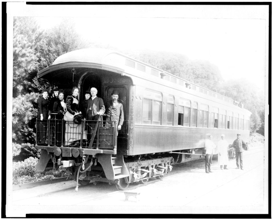 Henry M. Stanley and party standing on back of train at Monterey, California, March 19th, 1891, porters standing at side of car LCCN90712600