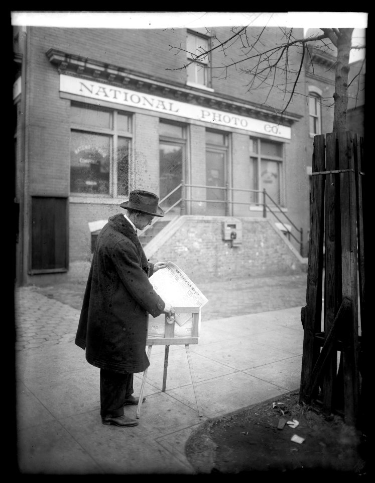 Herbert E. French, getting a paper from a paper box outside the National Photo Co. Building, Washington, D.C. LCCN2016852867