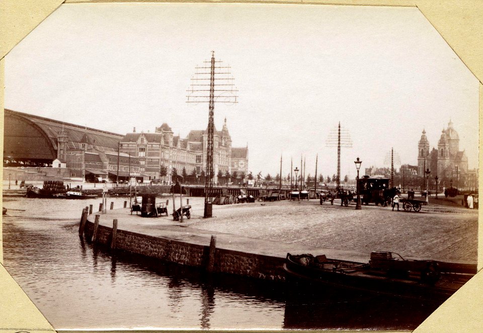 Het Centraal Station aan het Open Havenfront gezien in noordoostelijke richting met op de voorgrond de Prins Hendrikkade, op de achtergrond de Sint Nicolaaskerk