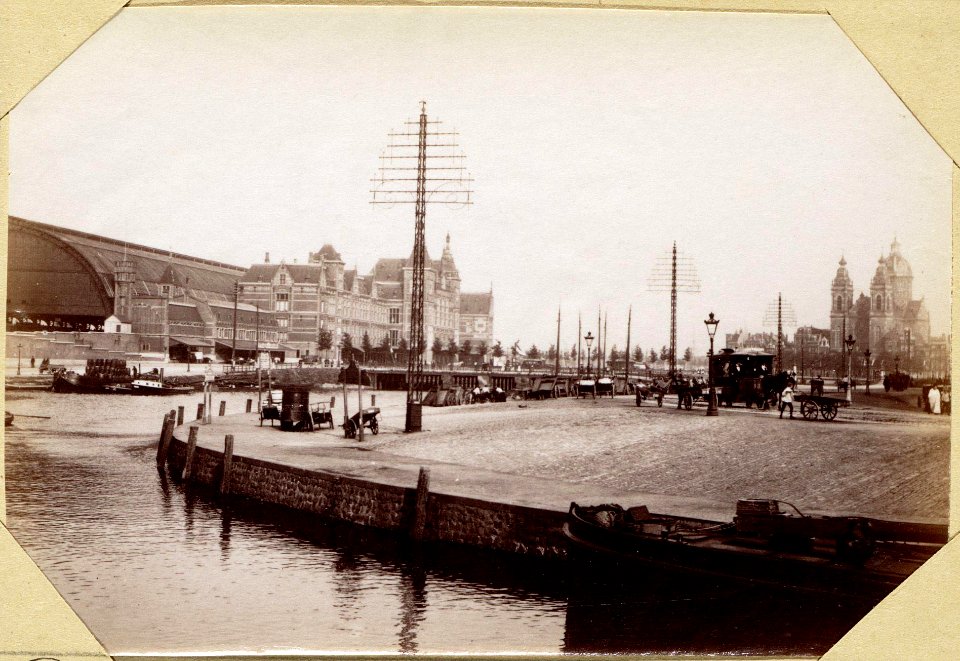 Het Centraal Station aan het Open Havenfront gezien in noordoostelijke richting met op de voorgrond de Prins Hendrikkade, op de achtergrond de Sint Nicolaaskerk photo