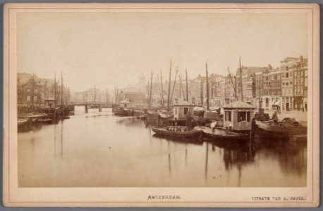 Het Damrak gezien in zuidelijke richting naar de Oudebrug en de oude Korenbeurs photo