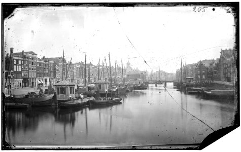 Het Damrak gezien in zuidelijke richting van de Nieuwebrug naar de Oudebrug en de oude Korenbeurs