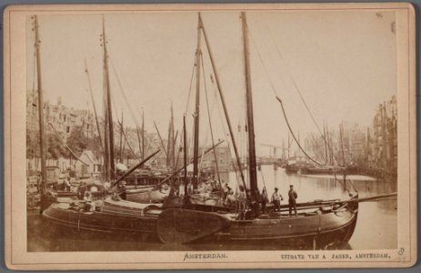 Het Damrak gezien vanaf de Papenbrug tot aan de Oudebrug met op de voorgrond een beurtschip photo