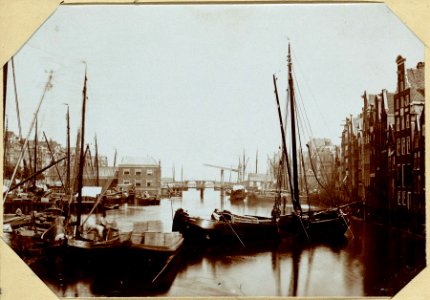 Het Damrak vóór de Demping, ziende van de Papenbrug naar de Oudenbrug - Op deze plaats is thans de Koopmansbeurs gebouwd -