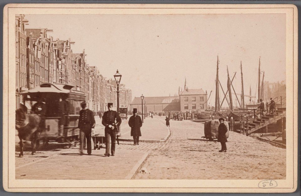 Het oude Damrak bij de voormalige Papenbrug met een wagen van de in 1876 geopende paardentramlijn Dam-Prins Hendrikkade en op de achtergrond de Korenbeurs-001