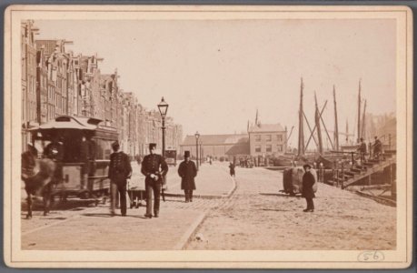 Het oude Damrak bij de voormalige Papenbrug met een wagen van de in 1876 geopende paardentramlijn Dam-Prins Hendrikkade en op de achtergrond de Korenbeurs-001 photo
