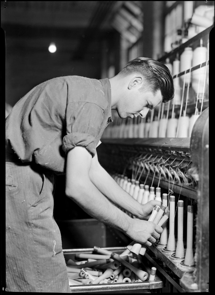 High Point, North Carolina - Textiles. Pickett Yarn Mill. Doffer in action - trying to portray doffer personality - NARA - 518518
