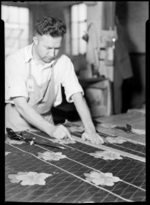 High Point, North Carolina - Upholstering. Tomlinson Chair Manufacturing Co. Cloth cutter - cutting cloth in pattern... - NARA - 518485