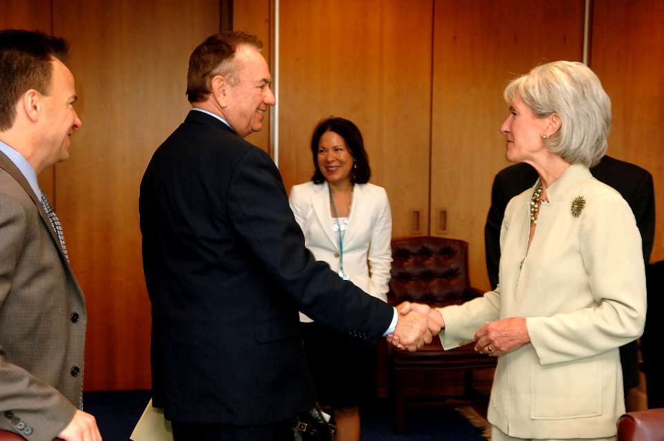 HHS Secretary Kathleen Sebelius shakes hands with former HHS Secretary Tommy Thompson, as White House Health Reform Director Nancy Ann DeParle, former Senate Majority Leader Tom Daschle, and Dr. Mark McClellan look on