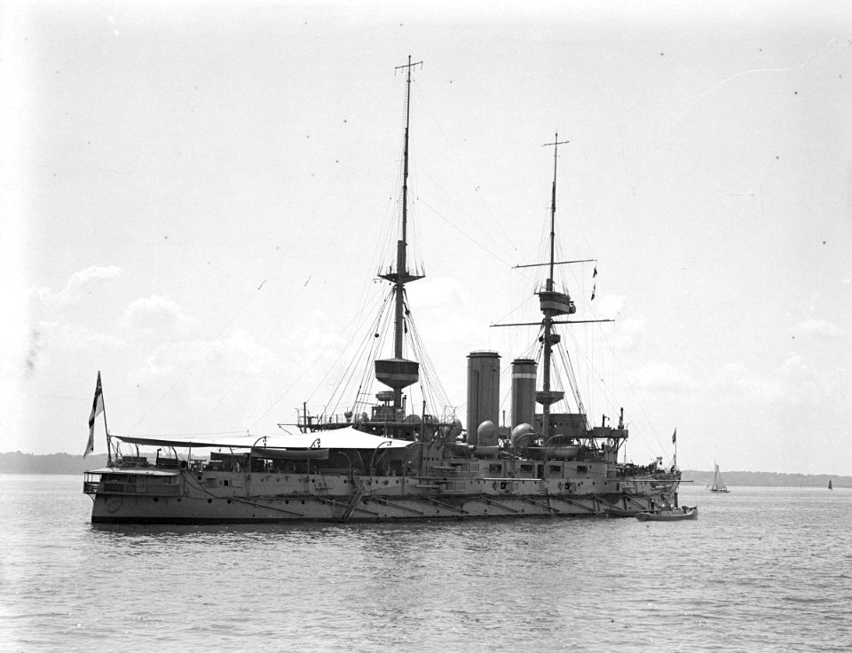 HMS 'Implacable' (1899) with awning rigged aft, anchored at Spithead. RMG P00033