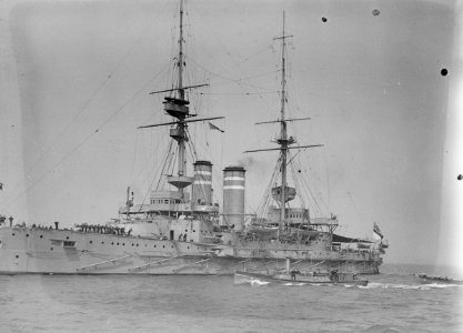 HMS 'Queen' (1902) with awning rigged aft, anchored at Spithead. RMG P00034