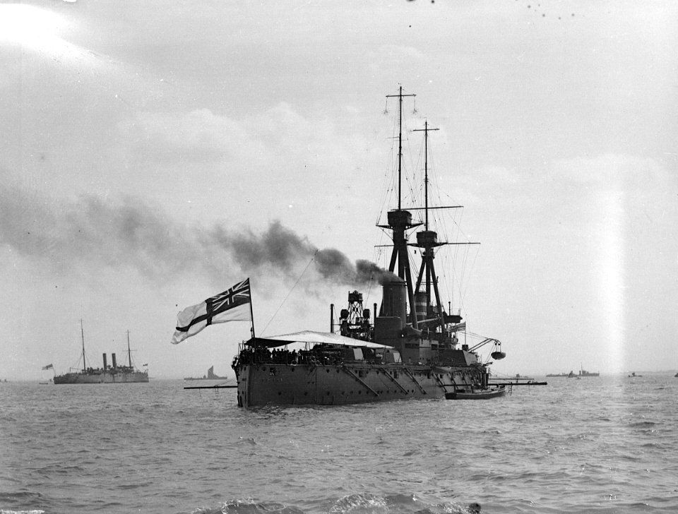 HMS 'Superb' (1907) with awning rigged aft, anchored in the Thames Estuary RMG P00032