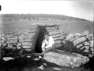 Home assegut a l'entrada d'una barraca de pedra seca (AFCEC RIBASV C 2533)