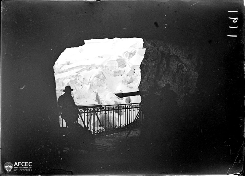 Homes amb un telescopi observant una glacera des d'un mirador excavat a la roca