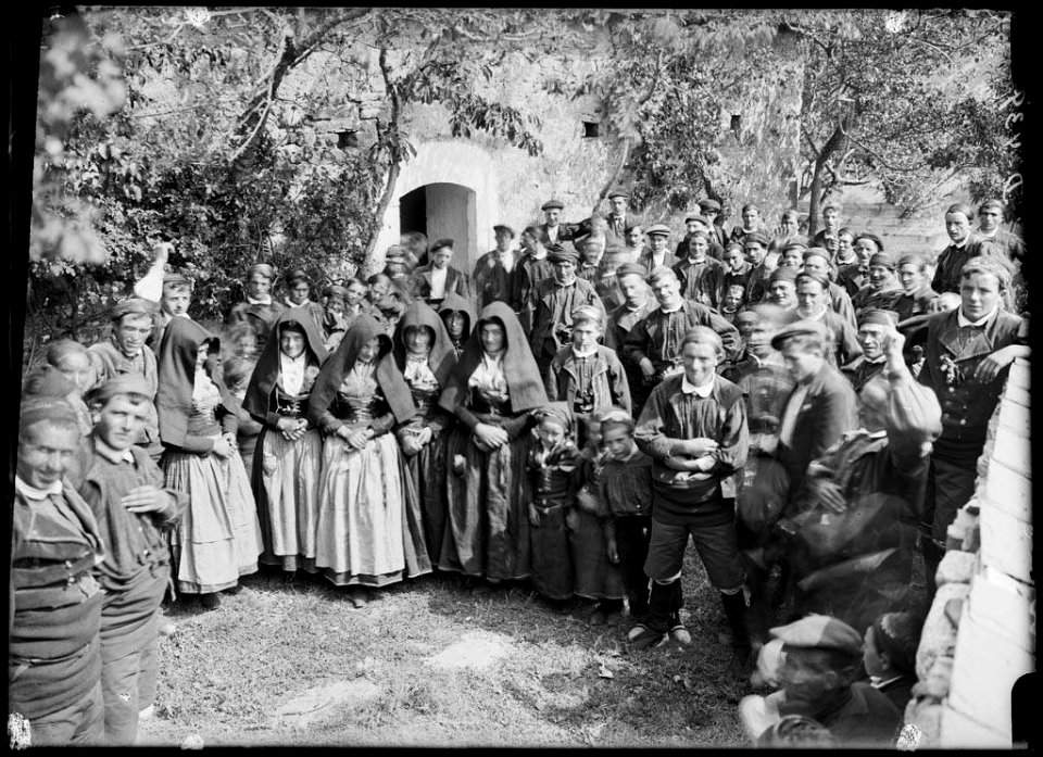 Homes, dones i nens amb vestits tradicionals sortint de Missa per Sant Fabià