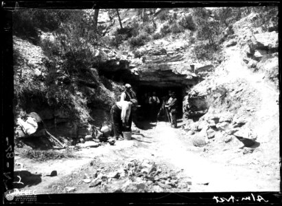 Homes amb càmera i trípode a l'entrada d'una cova d'Almatret