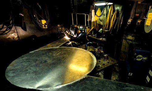 Sailor fabricates an arresting gear cover at sea. (9554193131)