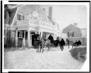 Horse-drawn sleighs with passengers in front of house LCCN95506271