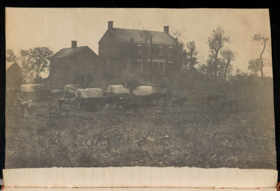 Horses and covered wagons in front of two-chimney brick house and outbuildings, probably at Camp Griffin, Langley, Virginia LCCN2014646385