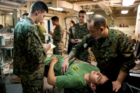 Hospital corpsman examine a patient during a mass causality drill. (25631130348)