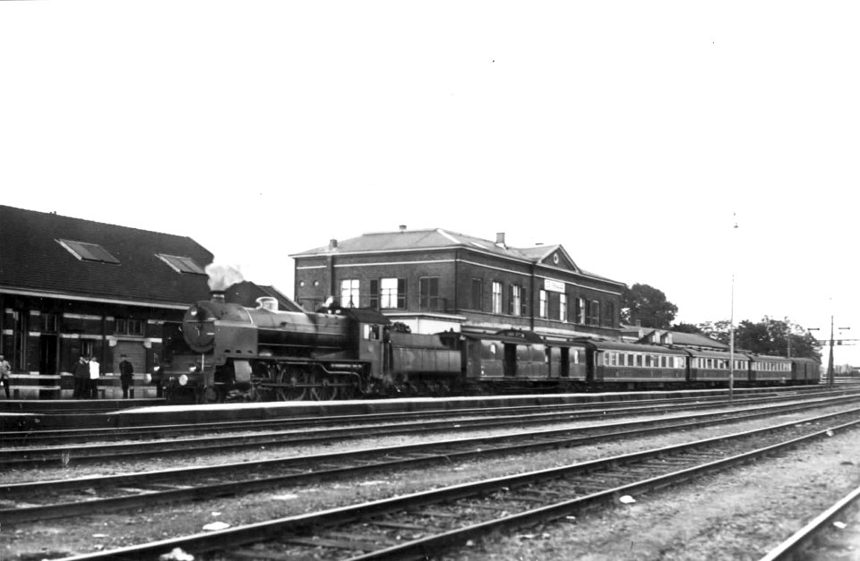 HUA-151302-Afbeelding van een stoomlocomotief van de N.S. (serie 3900) met internationale rijtuigen als D-trein Rheingold langs het perron van het N.S.-station te Zevenaar