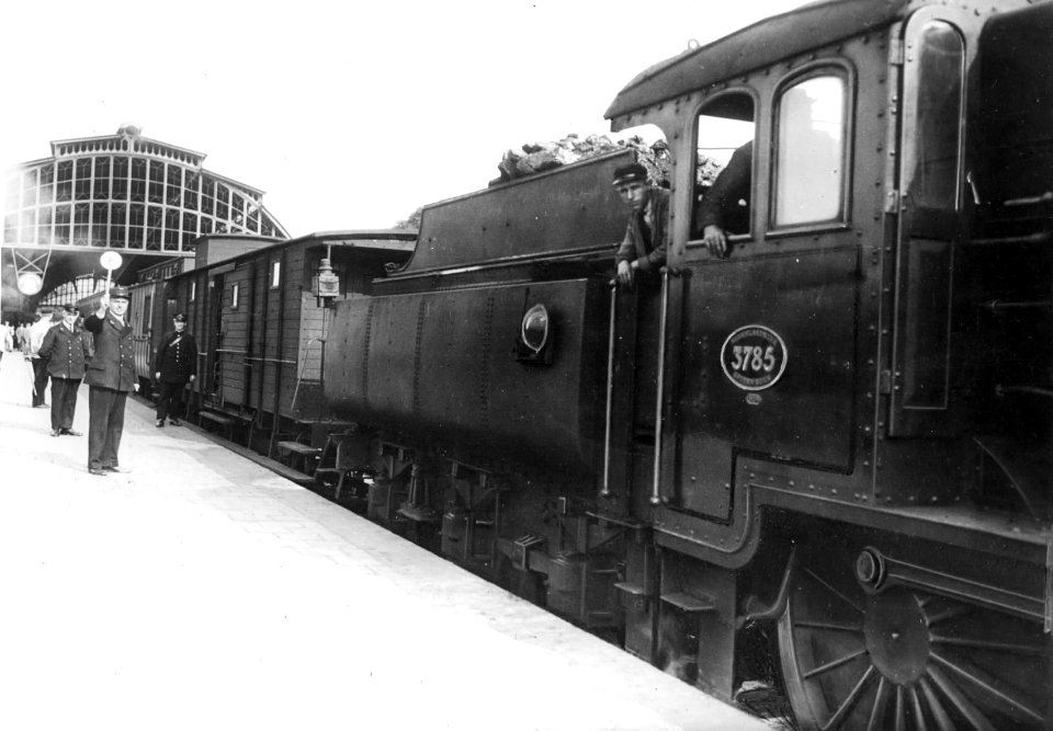 HUA-151296-Afbeelding van een gedeelte van de stoomlocomotief nr 3785 serie 3700 van de NS met rijtuigen langs het perron van het station te Den Haag SS te Den H