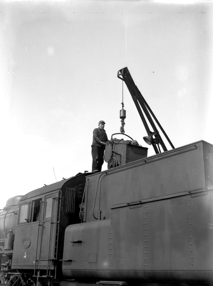 HUA-151463-Afbeelding van een gedeelte van de Zweedse 3 cilinder stoomlocomotief nr 4710 (serie 4700) van de N.S. tijdens het innemen van kolen in de kolenruimte van de tender door middel van een takel
