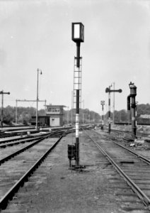 HUA-153922-Afbeelding van een rangeerpaallantaarn (rouwbrief) van de N.S. te Amersfoort met rechts een armsein en een waterkolom en links op de achtergrond het seinhuis Post VII aan de westzijde van het emplac