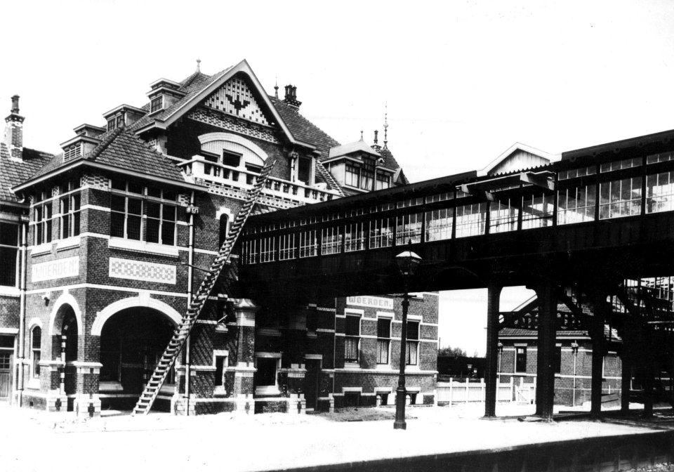 HUA-154688-Gezicht op de perronzijde en voetgangersbrug van het station Woerden van de Staatsspoorwegen te Woerden
