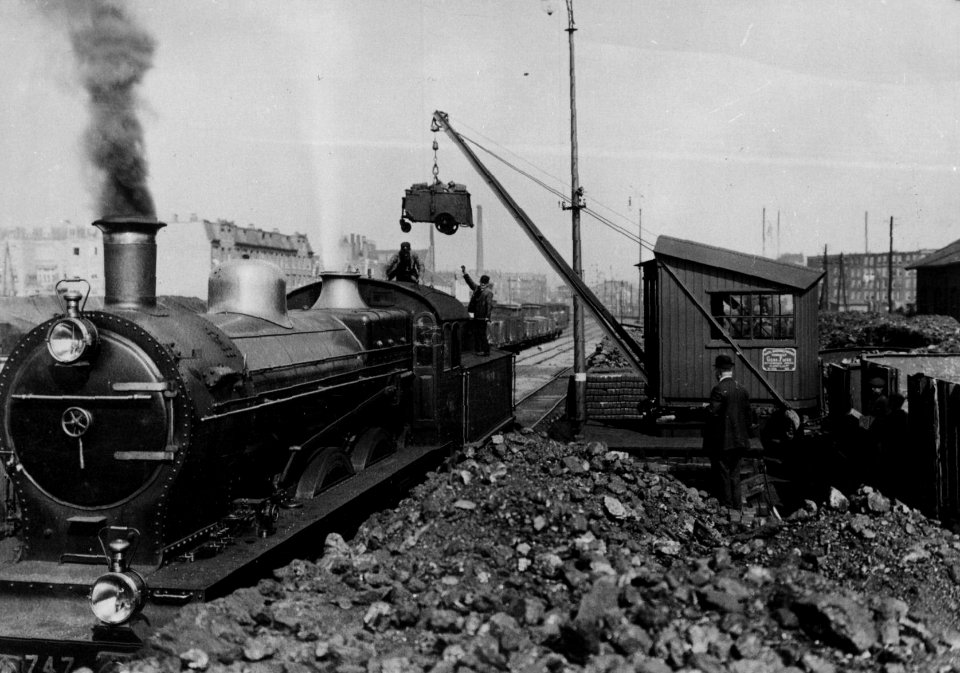 HUA-155228-Afbeelding van de stoomlocomotief nr. 747 (serie SS 685-799, later vernummerd tot de serie NS 3700-3800) van de Staatsspoorwegen tijdens het kolenladen bij het station Amsterdam Weesperpoort van de St
