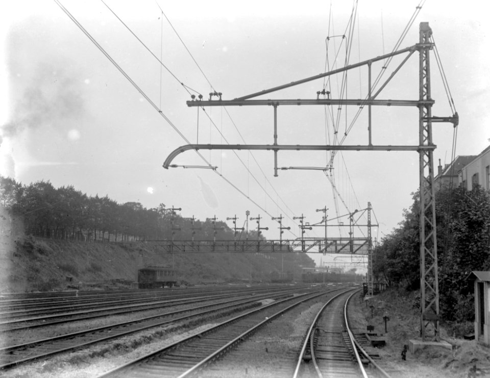 HUA-155233-Gezicht op het gedeeltelijk geëlectrificeerde emplacement aan de westzijde van het N.S.-station Arnhem te Arnhem met op de achtergrond de seinbrug