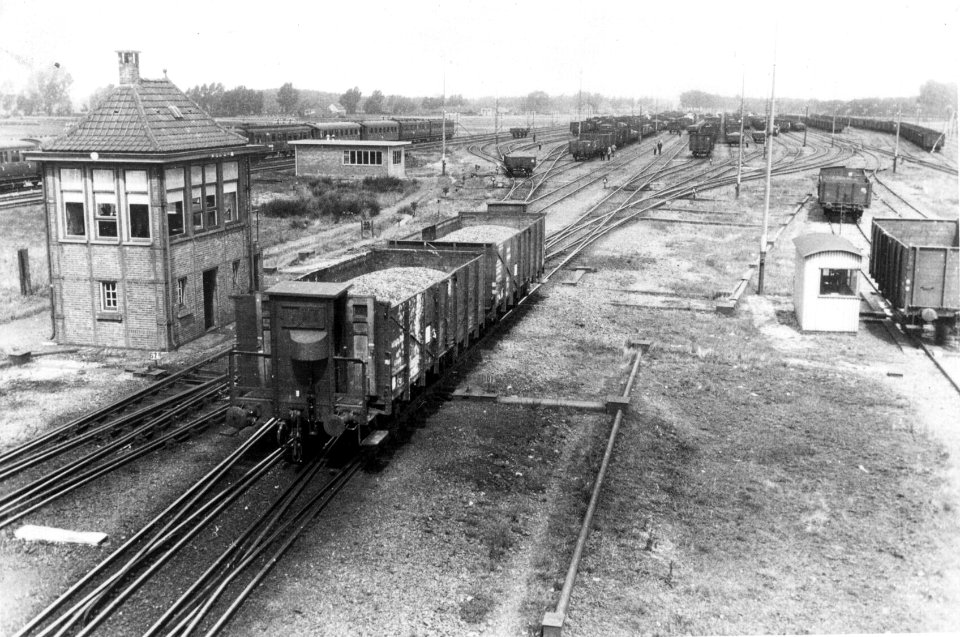 HUA-155240-Gezicht op het rangeerterrein te Susteren met links het seinhuis en twee goederenwagens die van de rangeerheuvel rollen