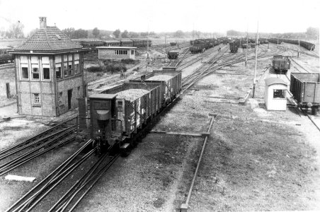 HUA-155240-Gezicht op het rangeerterrein te Susteren met links het seinhuis en twee goederenwagens die van de rangeerheuvel rollen
